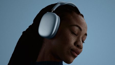 A woman wearing AirPods Max 2 in blue